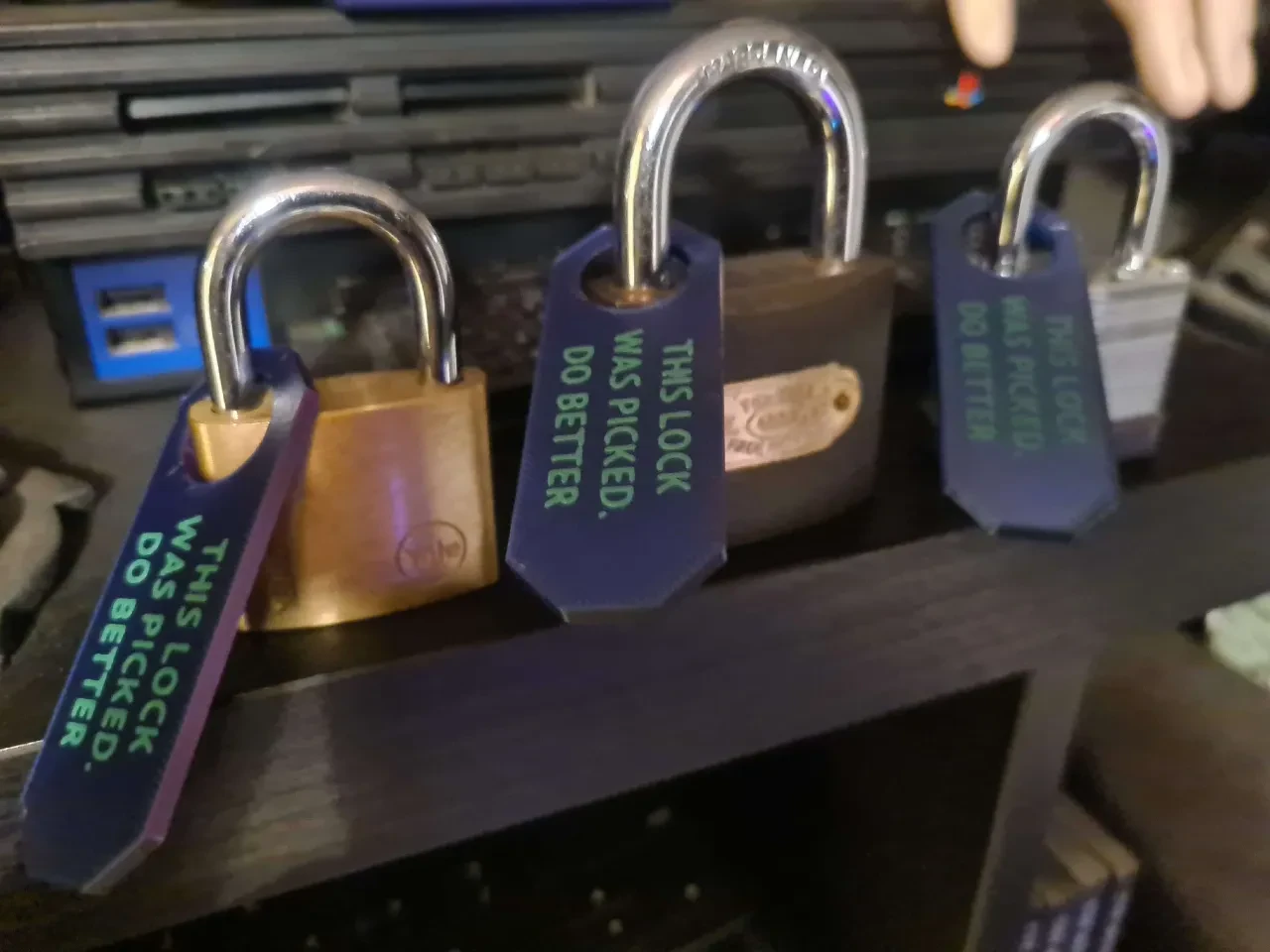 Three open padlocks fitted with tags reading This lock was picked. Do better.