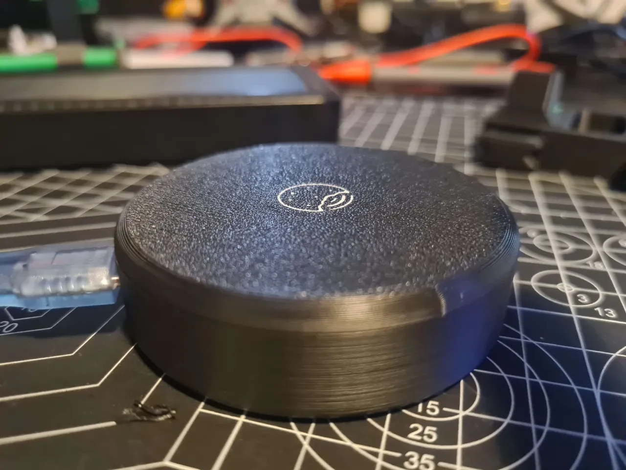 ESP32-C5 wardriving board inside a round black 3D-printed enclosure on a workbench
