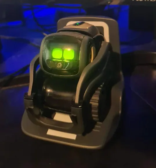 Anki Vector robot renamed Glitch sitting on its charger with bright green eyes